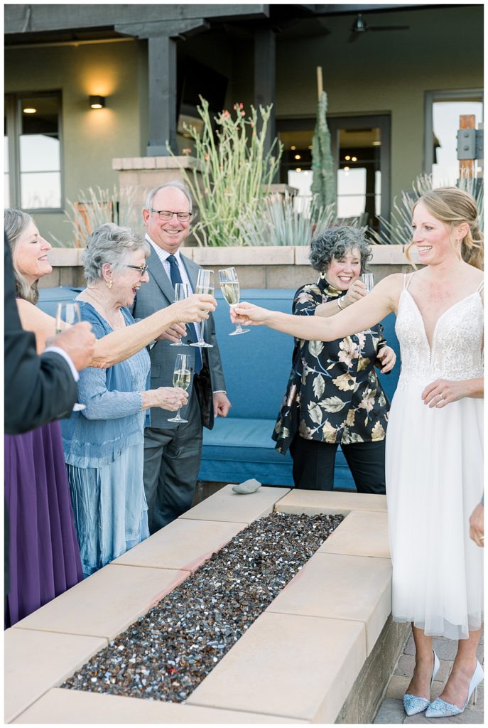 the bride and her parents share a champagne toast