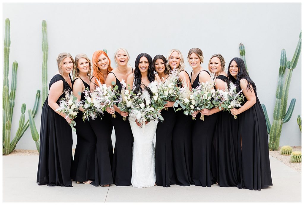 Bridesmaids wearing black surround a bride on her wedding day 