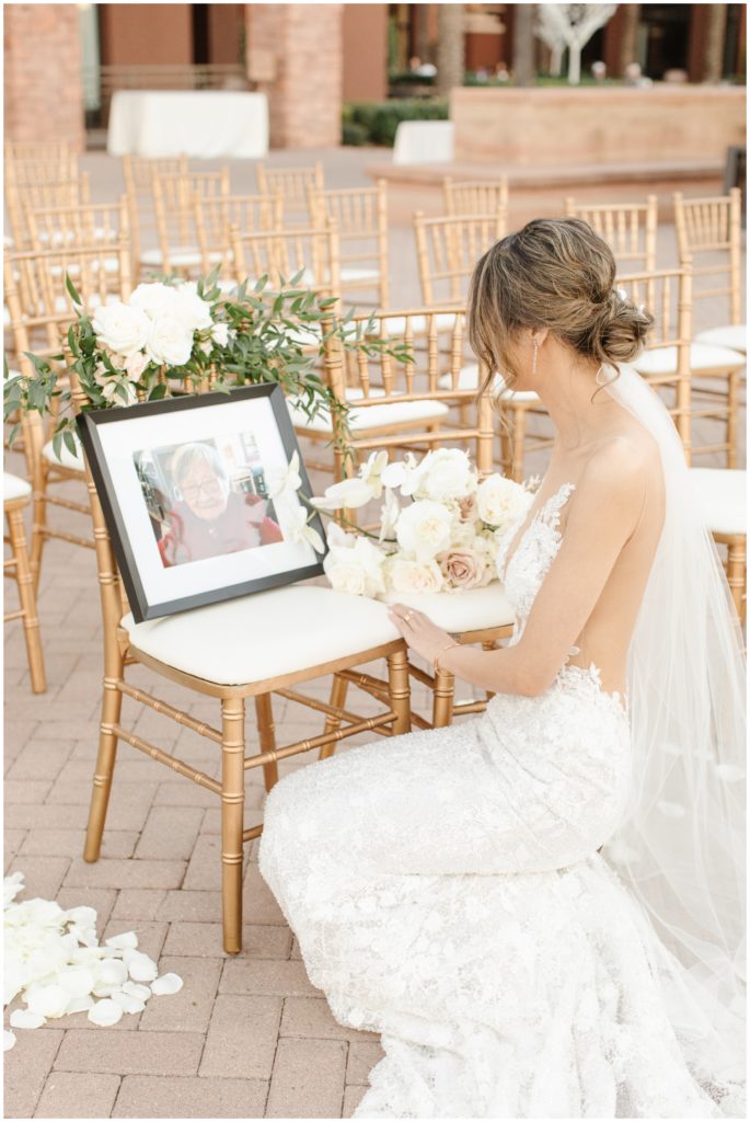 bride shares a moment with a photo of her loved one after her wedding ceremony